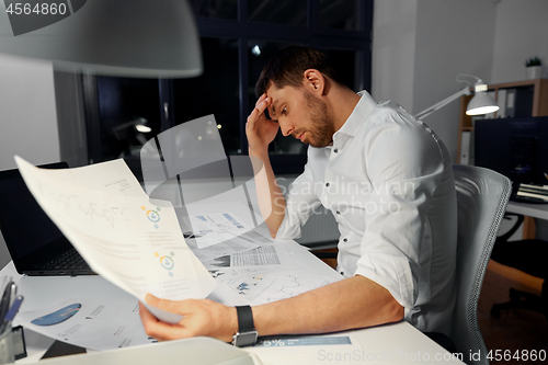 Image of businessman with papers working at night office