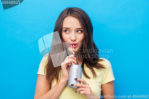 Image of young woman or teenage girl drinking soda from can