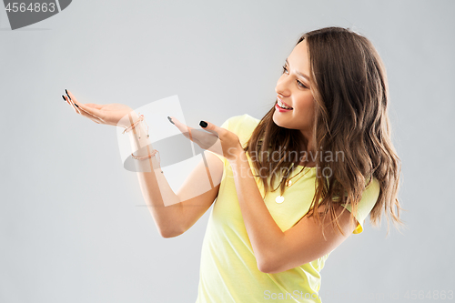 Image of happy teenage girl holding something imaginary