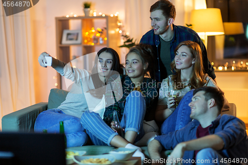 Image of happy friends taking selfie by smartphone at home