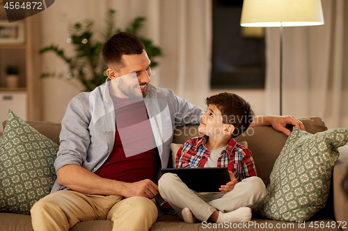 Image of father and son with tablet pc playing at home