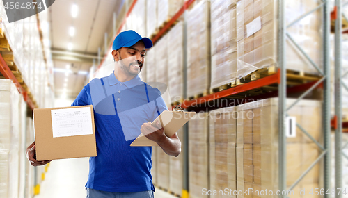 Image of delivery man with box and clipboard at warehouse