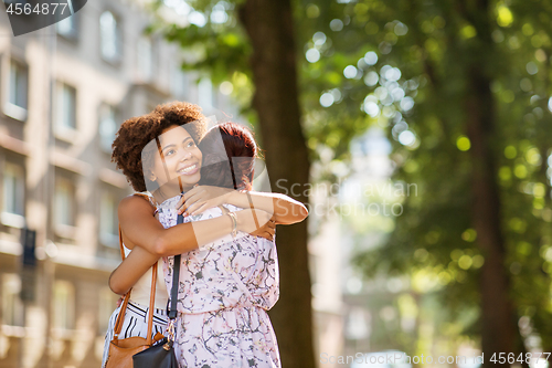 Image of young women or friends hugging at summer park