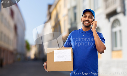 Image of delivery man with smartphone and parcel in city