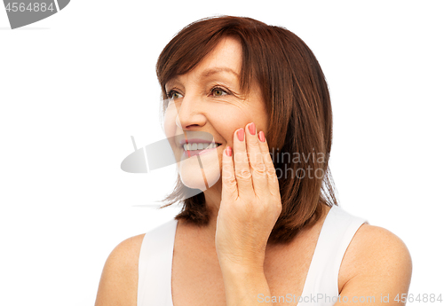 Image of portrait of smiling senior woman touching her face