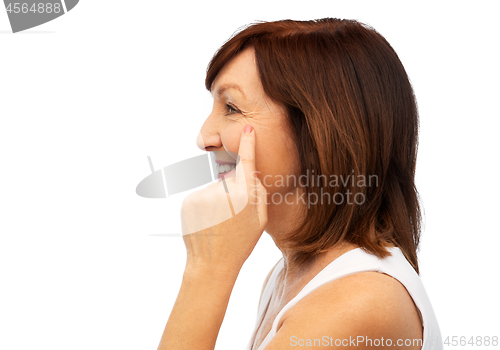 Image of profile of senior woman pointing to eye wrinkles