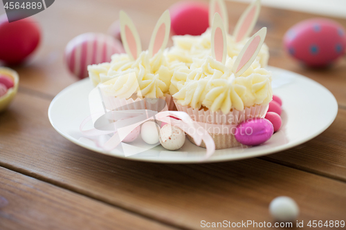 Image of cupcakes with easter eggs and candies on table