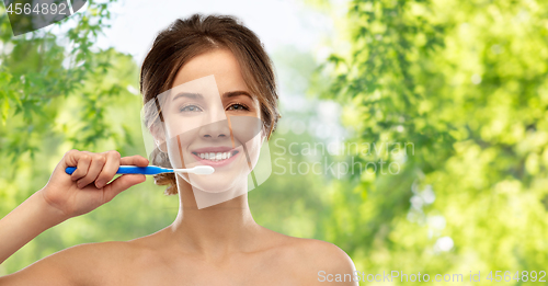 Image of smiling woman with toothbrush cleaning teeth