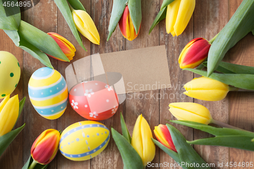 Image of close up of colored easter eggs and tulip flowers