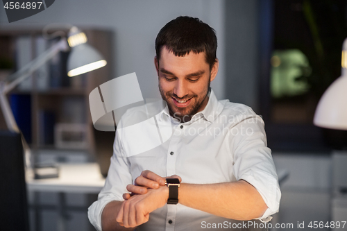 Image of happy businessman with smart watch at nigh office