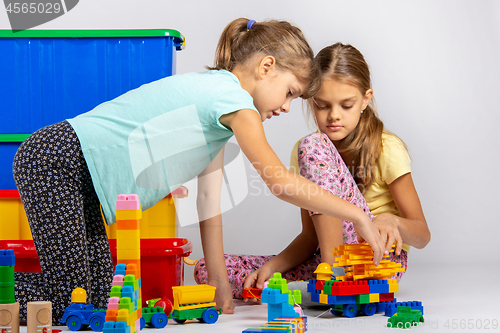 Image of Two girls collect figures from the designer