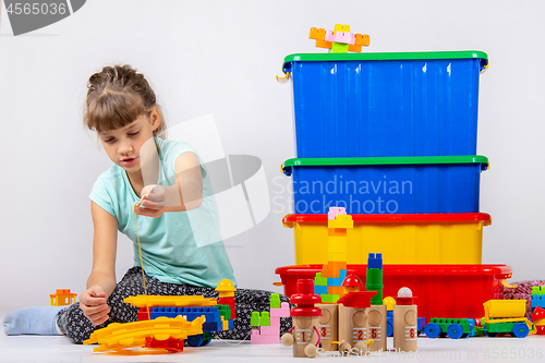 Image of Girl alone plays constructor and other toys