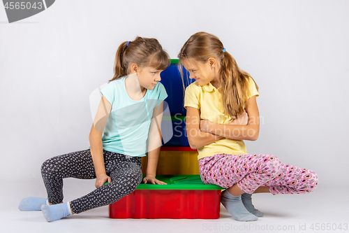 Image of Two girls quarreling, turned to each other with a displeased face