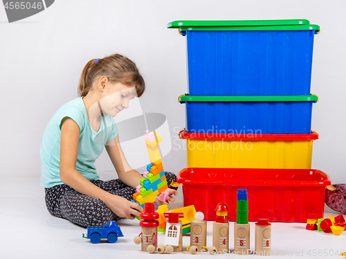 Image of Girl alone plays toys