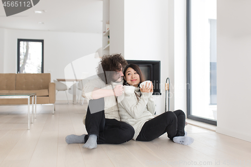 Image of happy multiethnic couple  in front of fireplace