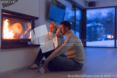 Image of happy couple in front of fireplace