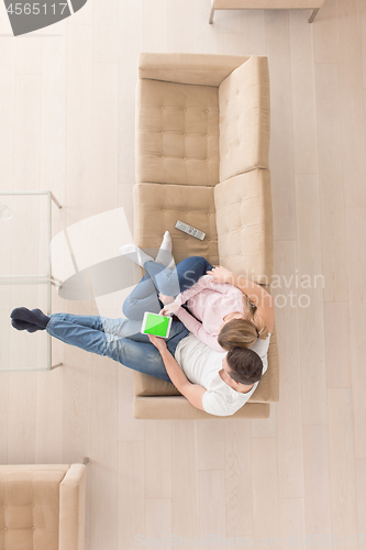 Image of young couple in living room using tablet top view