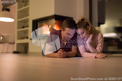 Image of Young Couple using digital tablet on cold winter night