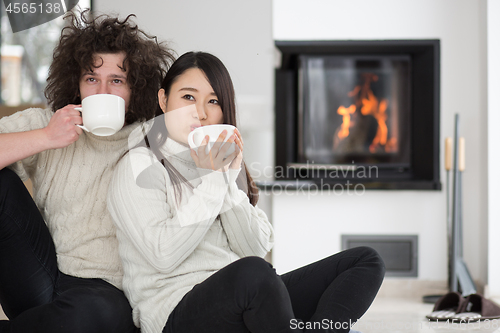 Image of happy multiethnic couple  in front of fireplace