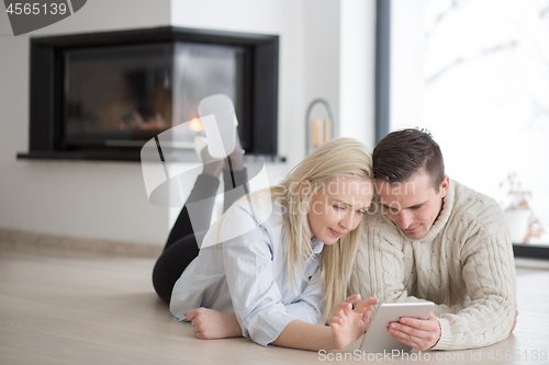 Image of Young Couple using digital tablet on cold winter day