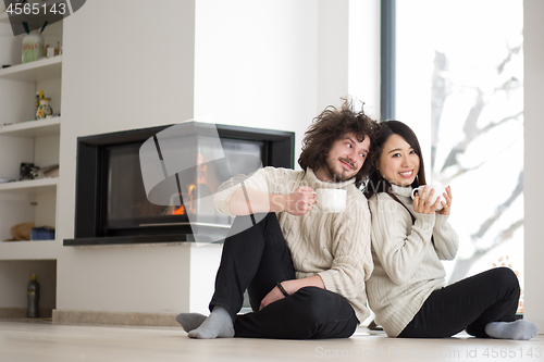 Image of happy multiethnic couple  in front of fireplace