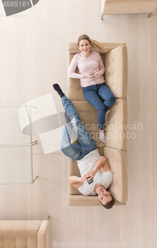 Image of Young couple on the sofa watching television top view