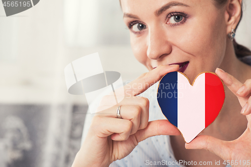 Image of Young woman with gingerbread heart cookies with flag