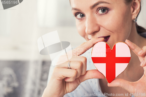 Image of Young woman with gingerbread heart cookies with flag