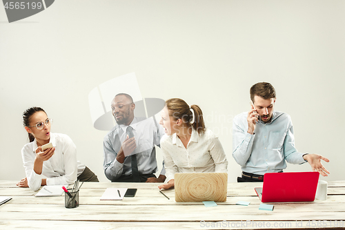 Image of Young men and women sitting at office and working on laptops. Emotions concept