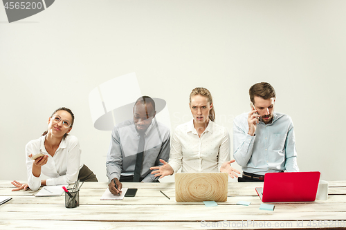 Image of Young men and women sitting at office and working on laptops. Emotions concept