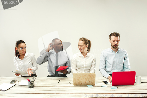 Image of Young men and women sitting at office and working on laptops. Emotions concept