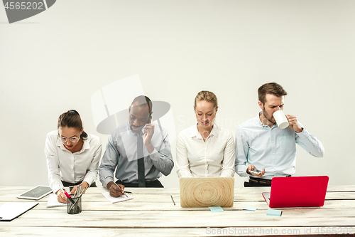 Image of Young men and women sitting at office and working on laptops. Emotions concept