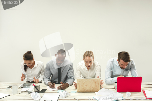 Image of Young men and women sitting at office and working on laptops. Emotions concept