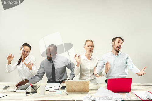 Image of Young men and women sitting at office and working on laptops. Emotions concept