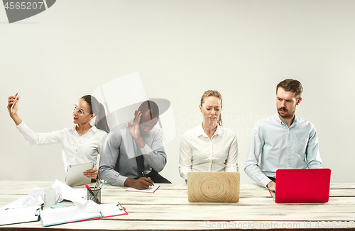 Image of Young men and women sitting at office and working on laptops. Emotions concept