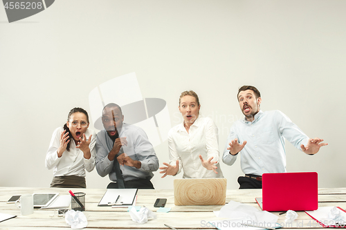 Image of Young men and women sitting at office and working on laptops. Emotions concept