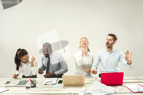 Image of Young men and women sitting at office and working on laptops. Emotions concept