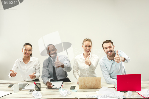 Image of Young men and women sitting at office and working on laptops. Emotions concept