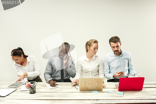 Image of Young men and women sitting at office and working on laptops. Emotions concept