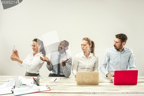 Image of Young men and women sitting at office and working on laptops. Emotions concept