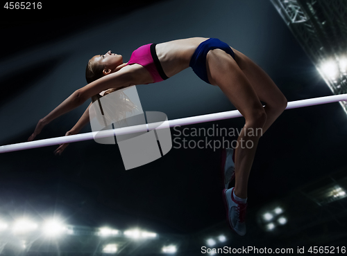 Image of female athlete in action high jump over bar in track and field