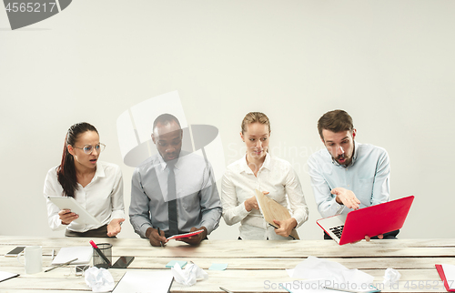 Image of Young men and women sitting at office and working on laptops. Emotions concept