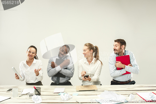 Image of Young men and women sitting at office and working on laptops. Emotions concept