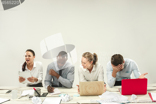 Image of Young men and women sitting at office and working on laptops. Emotions concept