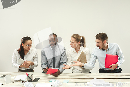 Image of Young men and women sitting at office and working on laptops. Emotions concept