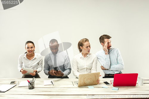 Image of Young men and women sitting at office and working on laptops. Emotions concept