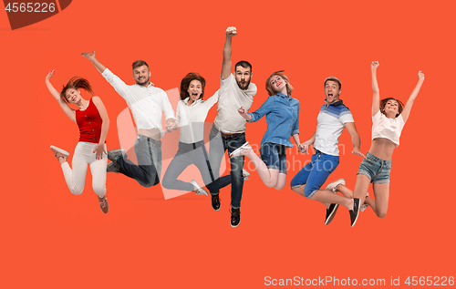 Image of Freedom in moving. young man and women jumping against red background