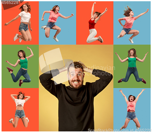 Image of Freedom in moving. young man and woman jumping against orange background