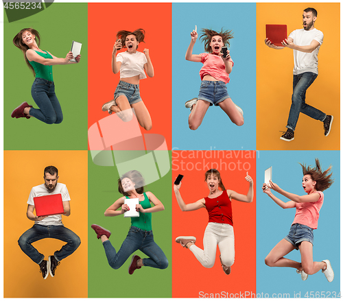 Image of The happy young jumping women and man with laptops and phone