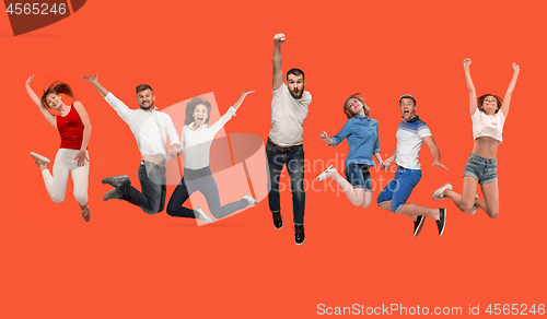 Image of Freedom in moving. young man and women jumping against red background